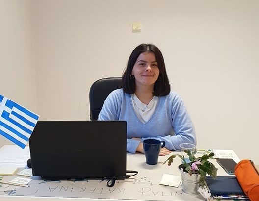 kobieta siedząca w biurze przy biurku przed laptopem