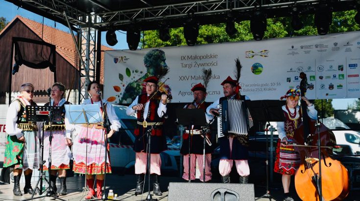 zespół folklorystyczny podczas występu na scenie plenerowej.